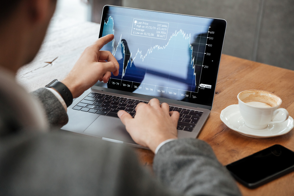 cropped-image-of-businessman-sitting-by-the-table-in-cafe-and-analyzing-indicators-on-laptop-computer